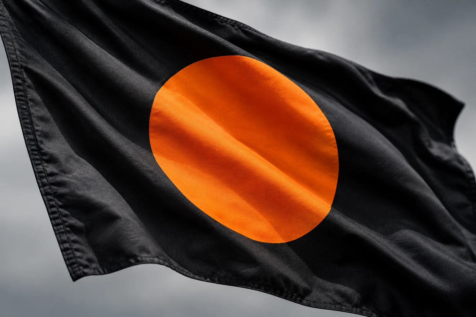 Detalle de tela negra con disco naranja creado con IA; ilustración conceptual sin bandera utilizada en una carrera real.